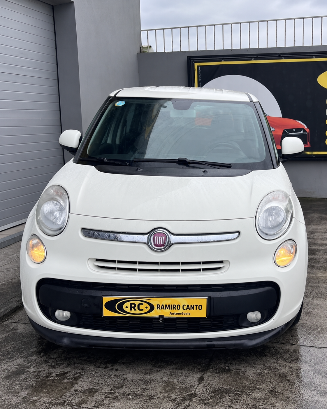 Fiat 500L diante do edifício.png